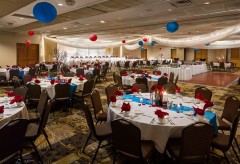 Setup for a wedding with a red and blue theme, round tables, and a buffet