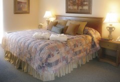 Large king bed with lots of pillows and two robes