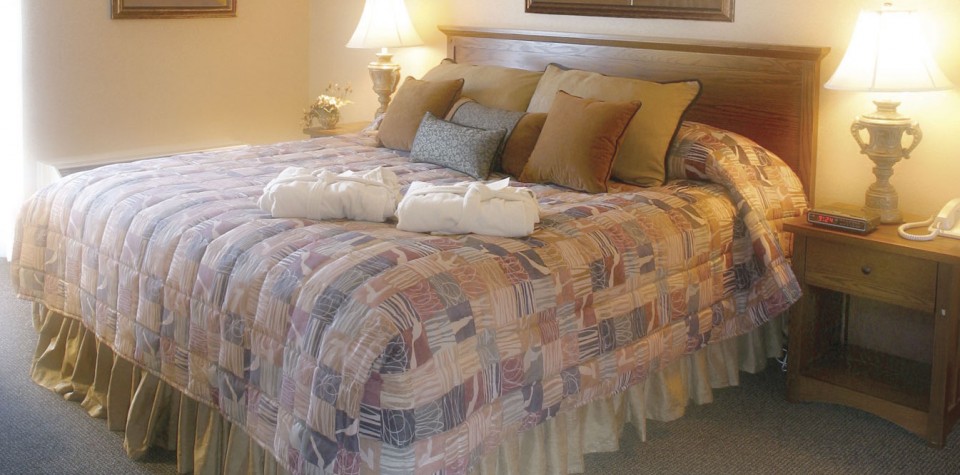 King bed with lots of pillows and two robes